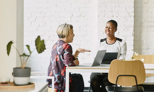 Smiling businesswomen discussion project in office conference room